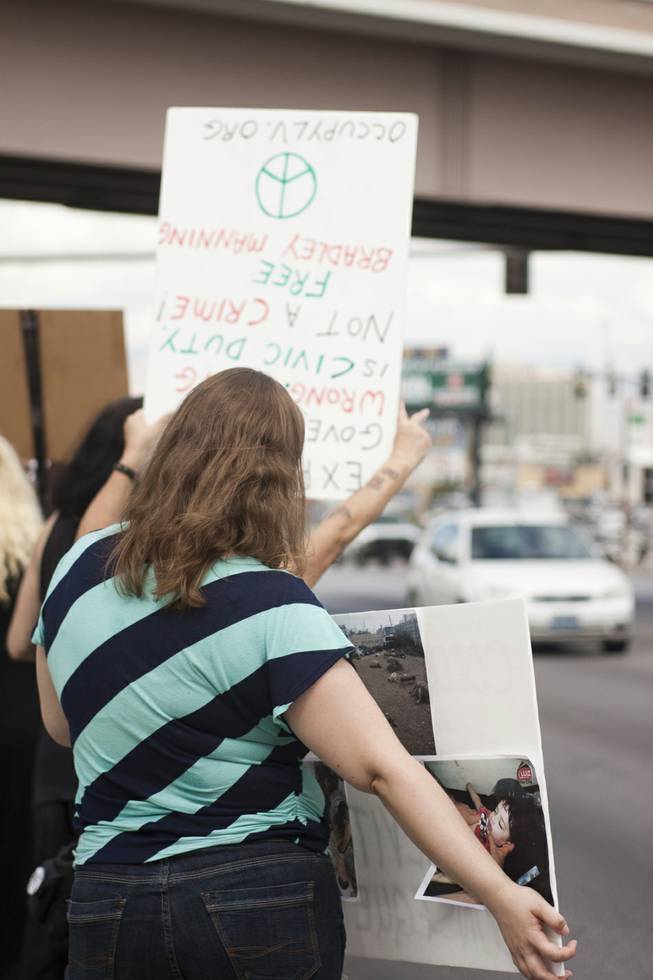 Protesters hold up signs to oncoming traffic during a protest against U.S. intervention in Syria held on Tropicana and the I-15, Saturday, Aug. 31, 2013.