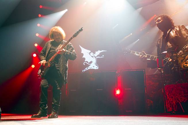 Black Sabbath bassist Geezer Butler performs at MGM Grand Garden Arena on Sunday, Sept. 1, 2013. A live projected image of guitarist Tony Iommi is at right.