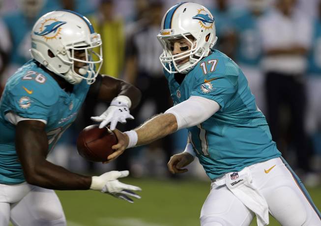 Miami Dolphins quarterback Ryan Tannehill (17) passes to running back Lamar Miller (26) during the first half of an NFL preseason football game against the Tampa Bay Buccaneers, Saturday, Aug. 24, 2013, in Miami Gardens, Fla. 