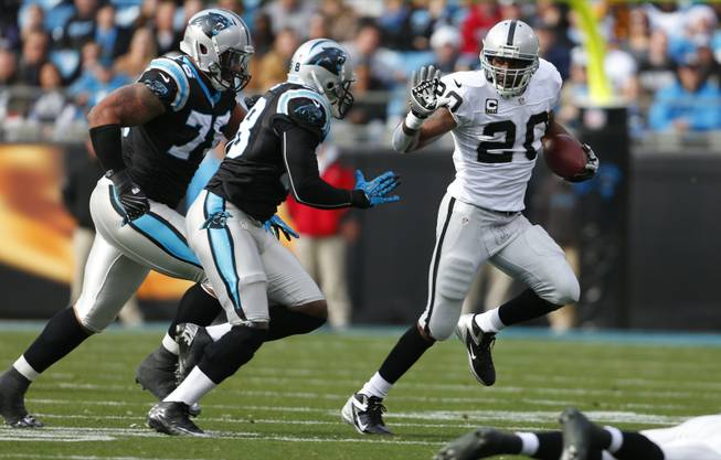 Oakland Raiders' Darren McFadden (20) runs as Carolina Panthers' Thomas Davis (58) and Greg Hardy (76) pursue during the first half of an NFL football game in Charlotte, N.C., Sunday, Dec. 23, 2012. 
