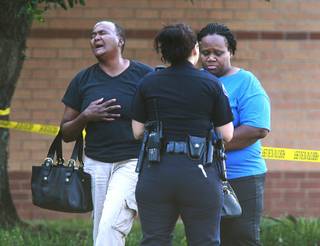 A pair of women react after a stabbing during a fight involving multiple students inside Spring High School Wednesday, Sept. 4, 2013, morning in Spring, Texas. 