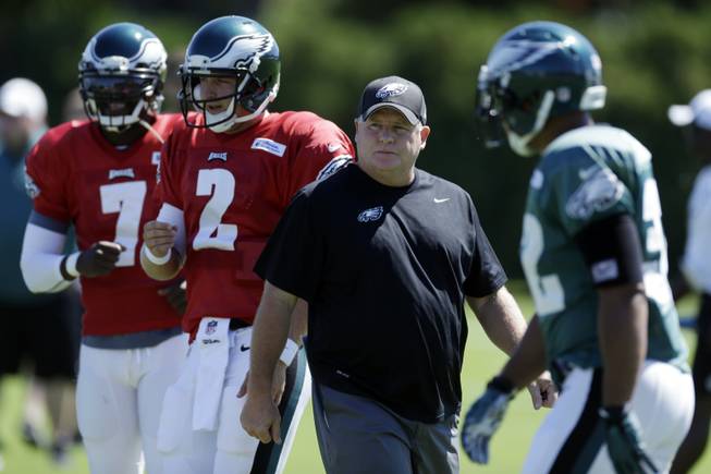 Philadelphia Eagles head coach Chip Kelly directs practice as quarterback Michael Vick, left, and Matt Barkley run a drill during NFL football practice at the team's training facility, Wednesday, Sept. 4, 2013, in Philadelphia. 