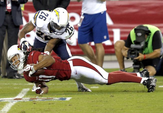 Arizona Cardinals wide receiver Larry Fitzgerald (11) lunges for the extra yards as San Diego Chargers defensive back Johnny Patrick (26) defends during the first half of a preseason NFL football game, Saturday, Aug. 24, 2013, in Glendale, Ariz.