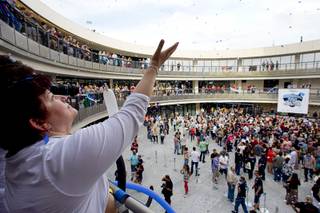 Zappos employee Ana Santiago catches confetti during the grand opening ceremony for the Zappos headquarters in the old city hall building downtown Monday, Sept. 9, 2013. According to RecordSetter, a record was set for the largest number of people (1,577 people) to cut a grand opening ribbon at the same time.