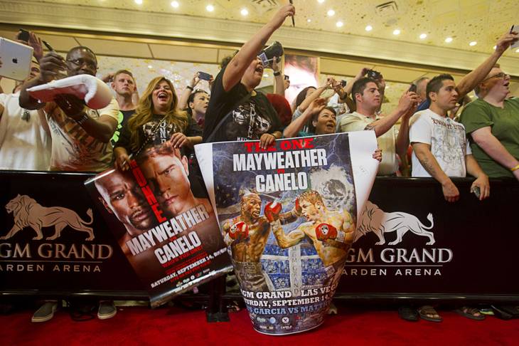 Fans try to get the attention of boxers during grand arrivals at the MGM Grand Tuesday, Sept. 10, 2013. Undefeated boxers Floyd Mayweather Jr. and Canelo Alvarez of Mexico will meet for a WBC/WBA 154-pound title fight at the MGM Grand Garden Arena on Saturday.