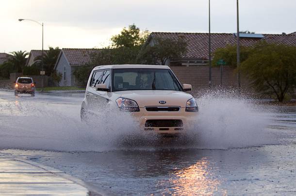 A car drives through storm runoff on El Capitan Way near Flamingo Road Wednesday, Sept. 11, 2013. 