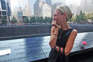 Carrie Bergonia of Pennsylvania looks over the name of her fiance, firefighter Joseph Ogren, at the 9/11 Memorial during ceremonies marking the 12th anniversary of the 9/11 attacks on the World Trade Center in New York, Wednesday, Sept 11, 2013. 