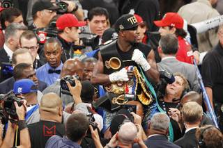 Floyd Mayweather holds his belts after defeating Canelo Alvarez during their super welterweight title fight Saturday, Sept. 14, 2013 at the MGM Grand Garden Arena. Mayweather won the fight with a majority decision.