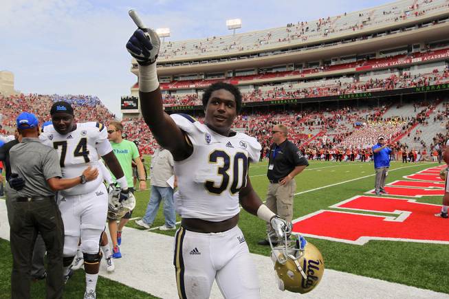 UCLA linebacker Myles Jack (30) celebrates a 41-21 win over Nebraska in an NCAA college football game in Lincoln, Neb., Saturday, Sept. 14, 2013. At left is UCLA guard Caleb Benenoch (74). 