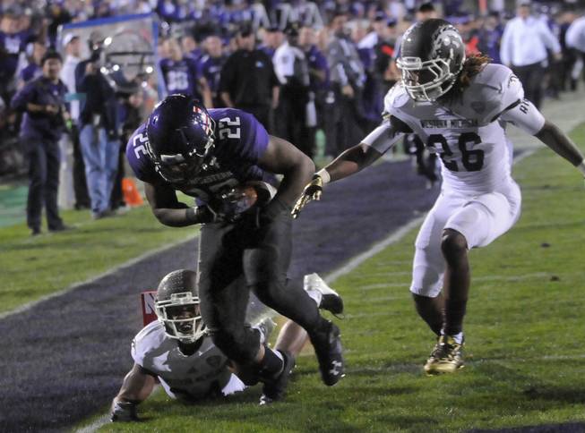 Northwestern's Treyvon Green (22) runs into the end zone after a touchdown against Western Michigan's Donald Celiscar (34) and Trevor Sweeney (25) during the fourth quarter of an NCAA college football game in Evanston, Ill.,  Saturday, Sept. 14, 2013.