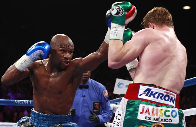 Floyd Mayweather Jr. throws a punch at WBC/WBA 154-pound champion Canelo Alvarez during their title fight at the MGM Grand Garden Arena Saturday, Sept. 14, 2013.