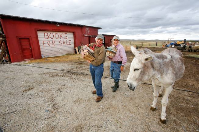 Lynda (Mad Dog) German, 66, left, and Polly (Pilgrim) Hinds, 58, owners of Mad Dog and The Pilgrim Booksellers in Sweetwater Station, Wyo., are photographed Sept. 15, 2013, with their donkey Rucia, next to a garage filled with 600 cases of books.