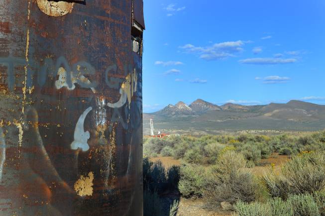 The drill pipe for the 1968 Project Faultless underground nuclear test is shown in the foreground. In the background is a rig drilling a test hole to determine if there has been any contamination of the groundwater, Sept. 15, 2013.