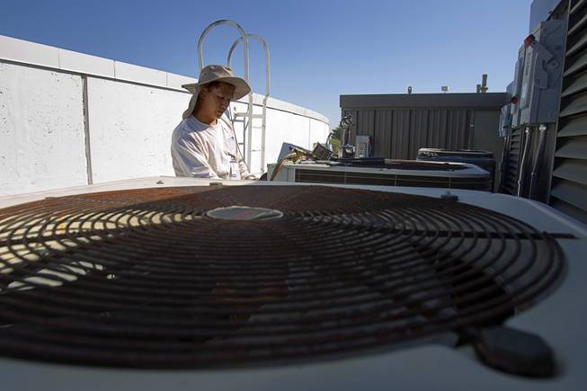 Tadone Phengrasamee, an HVAC technician for the Clark County School District, works on a unit at Cashman Middle School Tuesday, Sept. 17, 2013. As the effects of the recession continue to affect school operations and deferred maintenance costs continue to rise, the CCSD is finding it difficult to maintain school facilities.