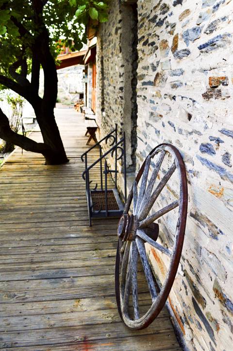 A wagon wheel sits along side of the Belmont Inn and Saloon.