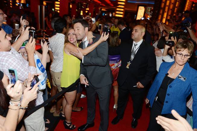 Ben Affleck poses for photos with a fan at the ...