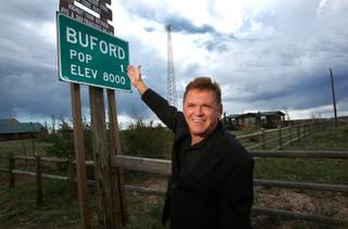 Don Sammons, former owner of the town of Buford, Wyoming, is photographed next to a sign indicating the town's population on September 18, 2013. The town consists of a convenience store, gas station, and modular home on 9.9 acres of land. The town was put up for auction on April 5, 2012, with the highest bid of $900,000 by Vietnamese entrepreneur Pham Dinh Nguyen.