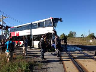 A city bus is severely damaged after colliding with a Via Rail passenger train at a crossing in Ottawa, Ontario, Wednesday, Sept. 18, 2013. 
