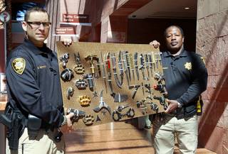 Clark County Deputy Marshals Mike Petty. left, and Ronald Ramsey show off a display of confiscated weapons and prohibited items at the Regional Justice Center Thursday, September 19, 2013.