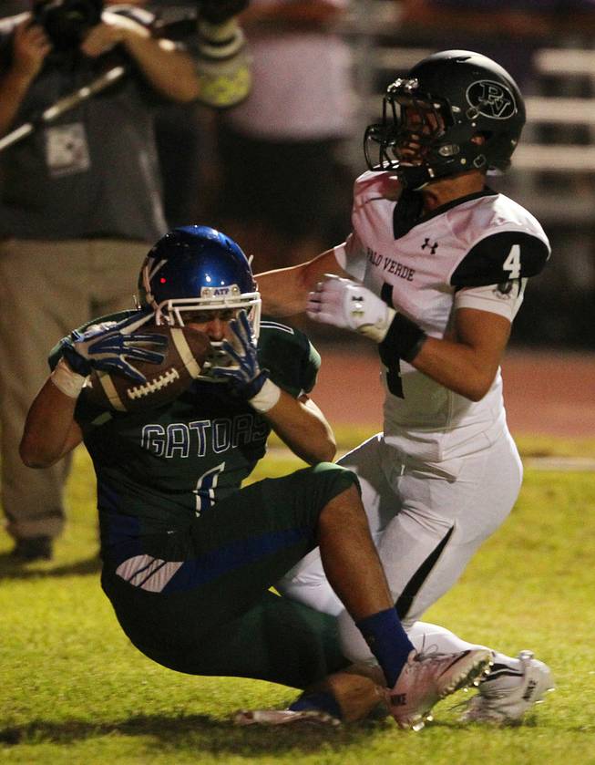 Green Valley wide receiver Gio Hernandez pulls in a touchdown pass while being covered by Palo Verde defensive back Darrion Finn during their game Friday, Sept. 20, 2013. Green Valley won the game in overtime 42-41.