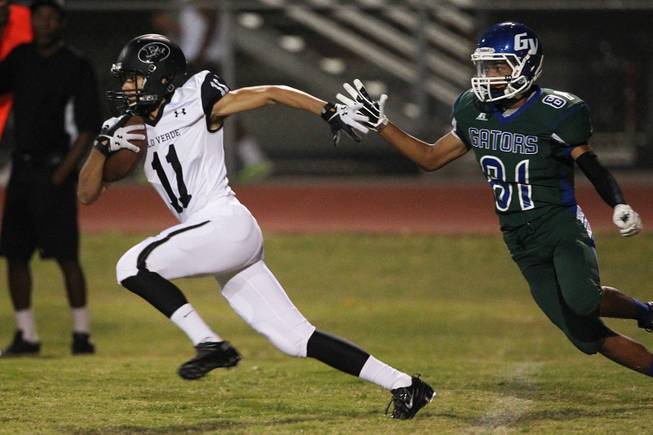 Palo Verde running back Ty Fuller gets past Green Valley defensive back Kyle Parker during their game Friday, Sept. 20, 2013. Green Valley won the game in overtime 42-41.