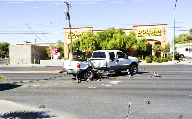The scene of a two-vehicle crash at Bonanza Road and Lamb Boulevard in which, Metro Police said, a pickup truck careened into a bus stop. Three children at the bus stop were injured, police said. The  white ford truck that hit a bus stop on bonanza, pieces of bus stop can be seen under car, Friday, Sept. 20, 2013.
