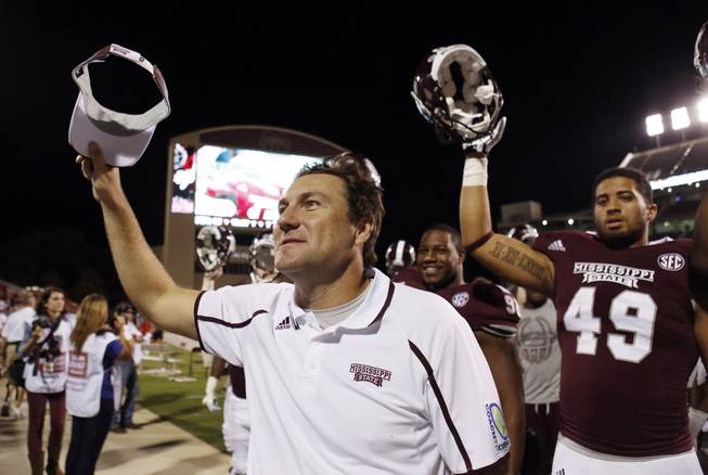 Mississippi State football coach Dan Mullen celebrates his team's 62-7 win over Troy in their NCAA college football game at Davis Wade Stadium in Starkville, Miss., on Saturday, Sept. 21, 2013. (AP Photo/