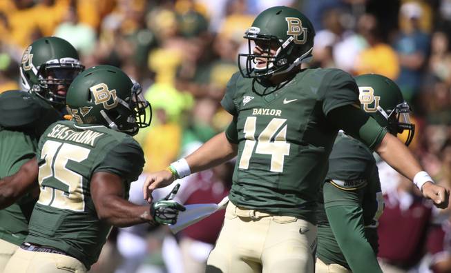 Baylor quarterback Bryce Petty (14) celebrates his touchdown against Louisiana-Monroe  with teammate Lache Seastrunk (25) during the first half of an NCAA college football game, Saturday, Sept. 21, 2013, in Waco, Texas. 