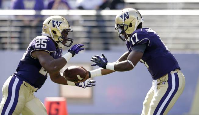 Washington's Keith Price (17) hands off to Bishop Sankey against Idaho State in the first half of an NCAA college football game Saturday, Sept. 21, 2013, in Seattle. 