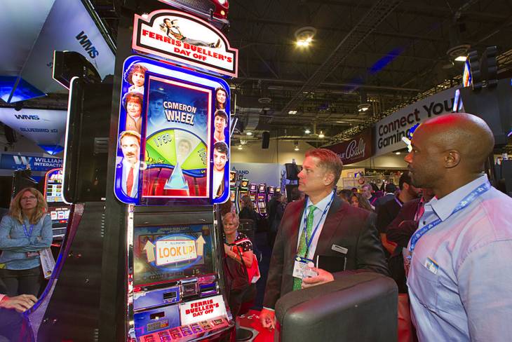 People look over a "Ferris Bueller's Day Off " video slot machines by WMS Gaming during the G2E convention at the Sands Expo Center Tuesday, Sept. 24, 2013. The slots are themed on the 1986 movie starring Matthew Broderick.