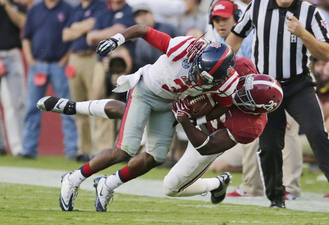 Mississippi running back Jeff Scott (3) is taken down by Alabama defensive back Landon Collins (26) during the first half of an NCAA college football game in Tuscaloosa, Ala., Saturday, Sept. 28, 2013. 