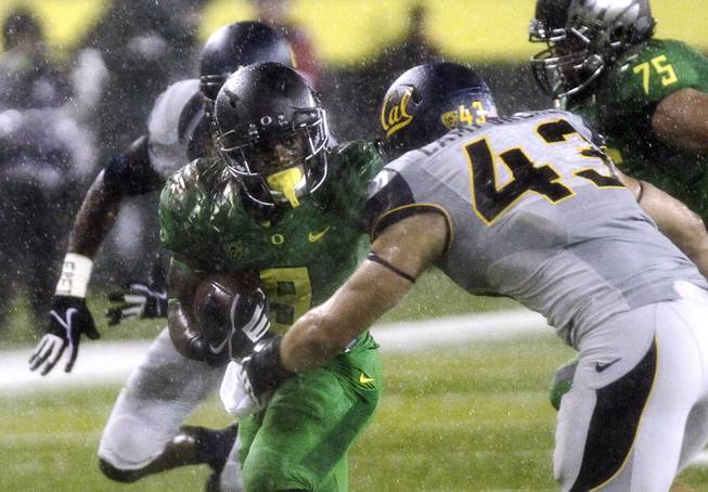 In this Sept. 28, 2013, file photo, Oregon running back Byron Marshall, left, tries to evade California defender Dan Camporeale during the first half of an NCAA college football game in Eugene, Ore. Marshall embodies Oregon's "Next Man In" philosophy. 