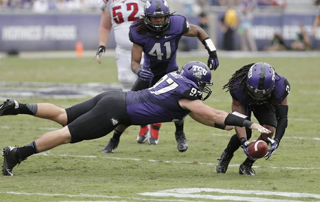 TCU defensive end Jon Koontz (97), cornerback Jason Verrett (2) and linebacker Jonathan Anderson (41) recover a SMU fumble during the first half of an NCAA college football game Saturday, Sept. 28, 2013, in Fort Worth, Texas. TCU won 48-17. 