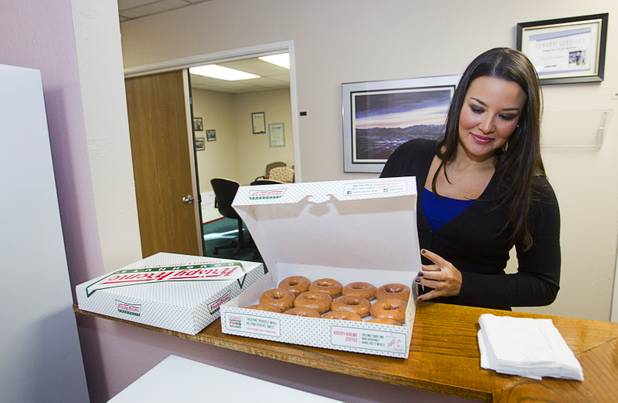 Jennifer Schwartz, a senior accountant at Houldsworth, Russo & Co., arrives with Krispy Kreme doughnuts at Help of Southern Nevada. Schwartz conducted an annual audit of the organization the same day. Firm owner Dianna Russo said she often provides treats for clients on the same day her staff will be performing audits of the companies so she can reward both her clients and employees with a single gesture. 