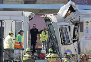 Authorities inspect the wreckage of two Chicago Transit Authority trains that crashed Monday, Sept. 30, 2013, in Forest Park, Ill. 
