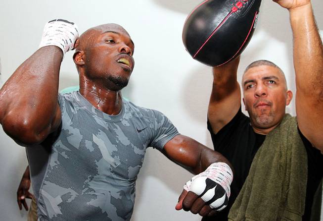 Undefeated WBO welterweight champion Timothy Bradley hits a speed bag during a media day workout in Indio, Calif. Tuesday, Oct. 1, 2013. Trainer Joel Diaz looks on at right. Bradley is preparing for his his upcoming title fight against Juan Manuel Marquez of Mexico at the Thomas & Mack Center on Oct. 12. .