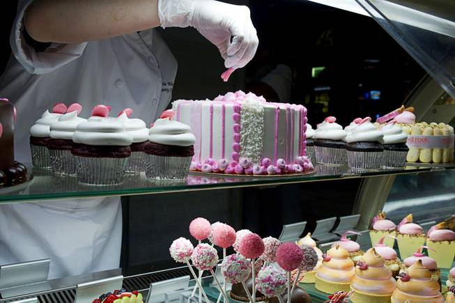 Pastry chef Katie Ward puts a pink candy ribbon on a cake at the Grand Cafe in the Red Rock Resort Tuesday, Oct. 1, 2013. Station Casinos is hosting its fourth annual "Project Pink" initiative for National Breast Cancer Awareness Month. Throughout October, the majority of station properties will donate a portion of its proceeds from Project Pink retail sales and Pink gaming winnings to the Southern Nevada affiliate of Susan G. Komen, an organization supporting breast cancer research.