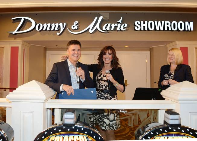 Flamingo Las Vegas Regional President Eileen Moore, right, Donny Osmond and Marie Osmond unveil the signage for the newly renamed Donny & Marie Showroom at Flamingo Las Vegas on Wednesday, Oct.  2, 2013.