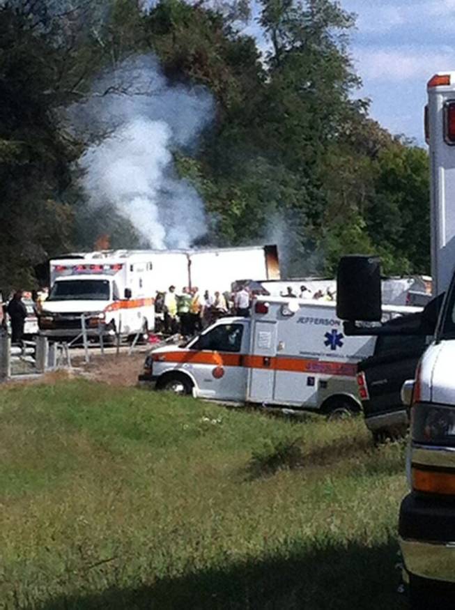 In this image released by WATE, authorities work at the scene of an interstate accident, near Dandridge, Tenn. on Wednesday, Oct. 2, 2013. A passenger bus has overturned in Jefferson County, completely blocking the eastbound lanes of Interstate 40. 