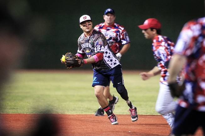 Saul Bosquez of the Wounded Warrior Amputee Softball Team makes a play during an exhibition game with players participating in the LVSSA/SSUSA World Masters Championships softball tournament at the Big League Dreams Park in Las Vegas on Friday, October 4, 2013.