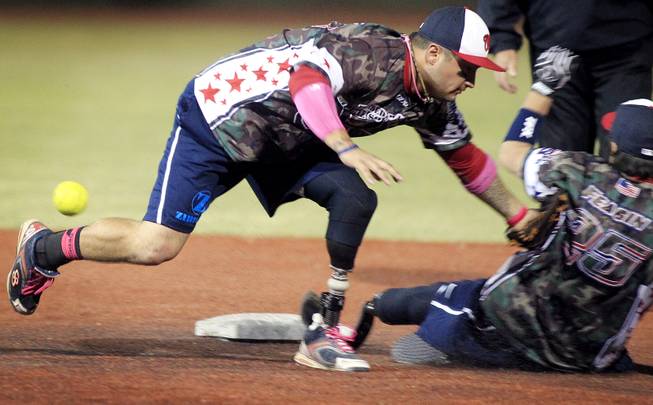 Wounded Warrior Amputee Softball Team player Saul Bosquez tries to tag teammate Mike Gallardo, but he is safe at second base during an exhibition game with players participating in the LVSSA/SSUSA World Masters Championships softball tournament at the Big League Dreams Park in Las Vegas on Friday, October 4, 2013.