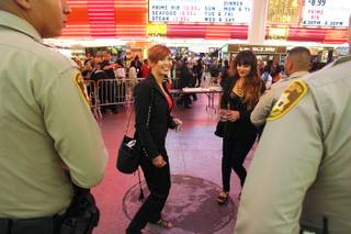 Anna Pokrovskaya, left, and Zlata Pavlova ask Metro officers if they can have a photo taken with them at the  Fremont Street Experience early Saturday, Oct. 5, 2013.