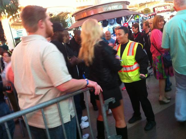 A woman waits for instructions from a security guard before passing a barricade at the Fremont Street Experiece on Friday, Oct. 4, 2013.
