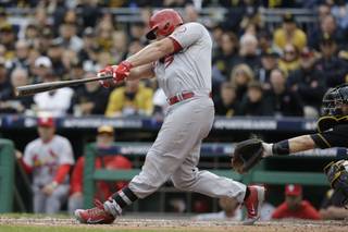St. Louis Cardinals' Matt Holliday swings on a home run that scored Carlos Beltran in the sixth inning of Game 4 of a National League baseball division series against the Pittsburgh Pirates on Monday, Oct. 7, 2013, in Pittsburgh.