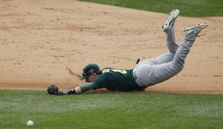 Oakland Athletics shortstop Jed Lowrie dives but is unable to stop the single by Detroit Tigers' Prince Fielder during the sixth inning of Game 3 of an American League baseball division series in Detroit, Monday, Oct. 7, 2013.