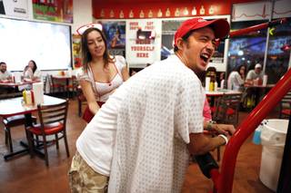 Reginaldo Tomitake of Brazil receives a spanking from waitress Jessica Diaz for not finishing his burger at the Heart Attack Grill in downtown Las Vegas on Tuesday, October 8, 2013.