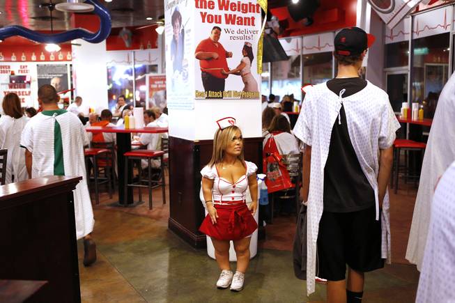 Lorren Cackowski, a waitress at the Heart Attack Grill, greets customers in downtown Las Vegas on Tuesday, October 8, 2013.