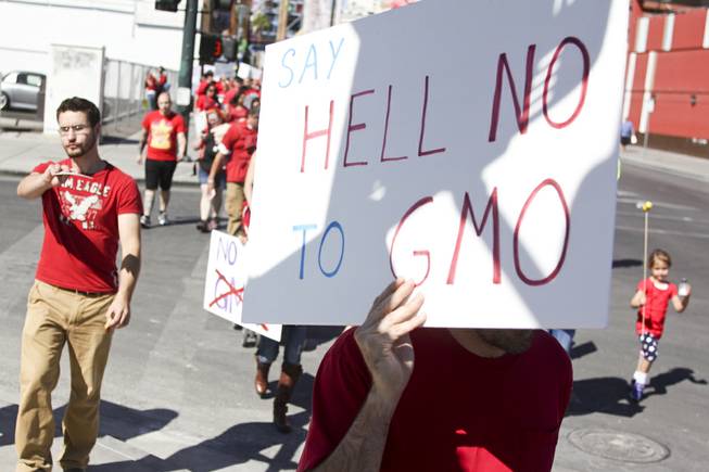 Protesters walk down Fremont Street during the "March Against Monsanto" protest opposing genetically modified food in downtown Las Vegas, Saturday, Oct. 12, 2013.