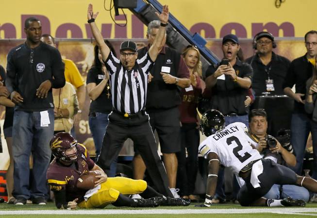 Arizona State's Taylor Kelly, bottom left, hangs on to the football as he beats Colorado's Kenneth Crawley (2) to the end zone as field judge Steven Strimling signals for the touchdown during the first half of an NCAA college football game on Saturday Oct. 12, 2013, in Tempe, Ariz. 