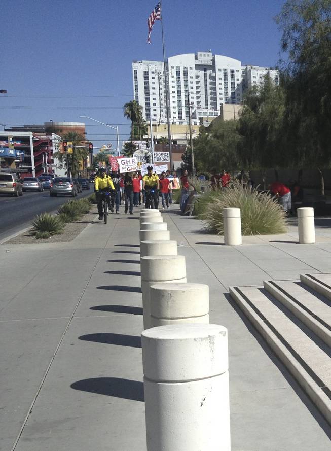 Metro Police officers lead anti-GMO marchers to the U.S. district courthouse steps in downtown Las Vegas on Saturday, Oct. 12, 2013.